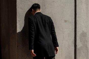 Person leaning with their head against a wall