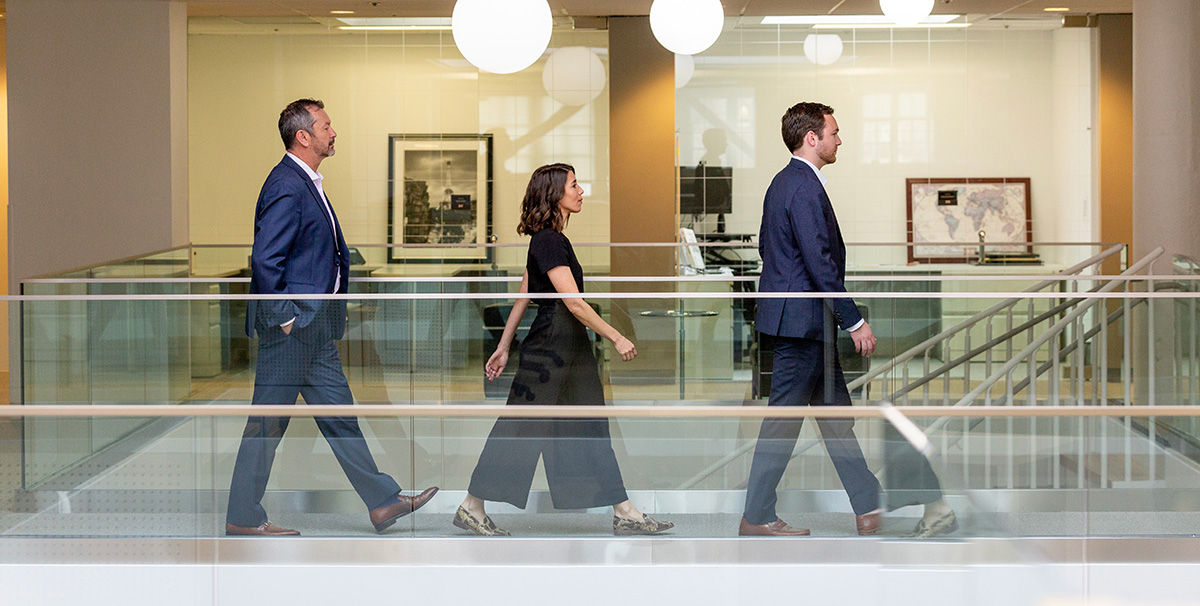 Image of three people walking in an office building