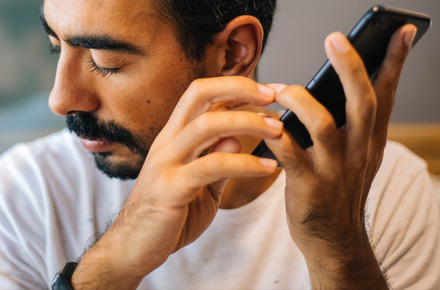 Man holding a phone listening to a screen reader