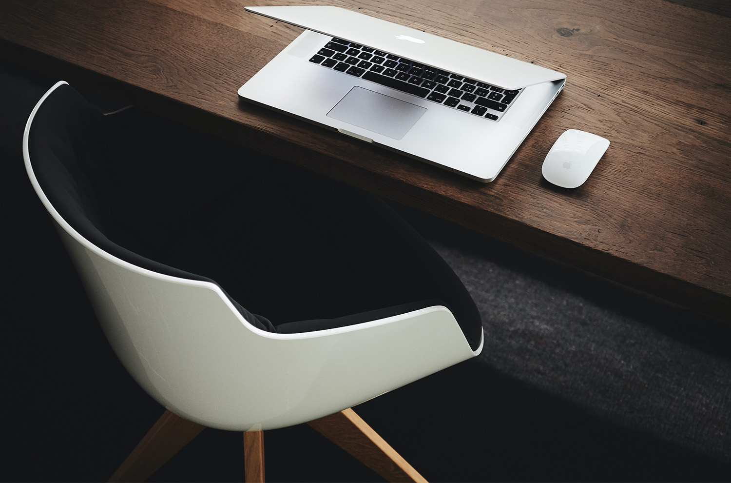 View of a wooden desk, chair, and a laptop